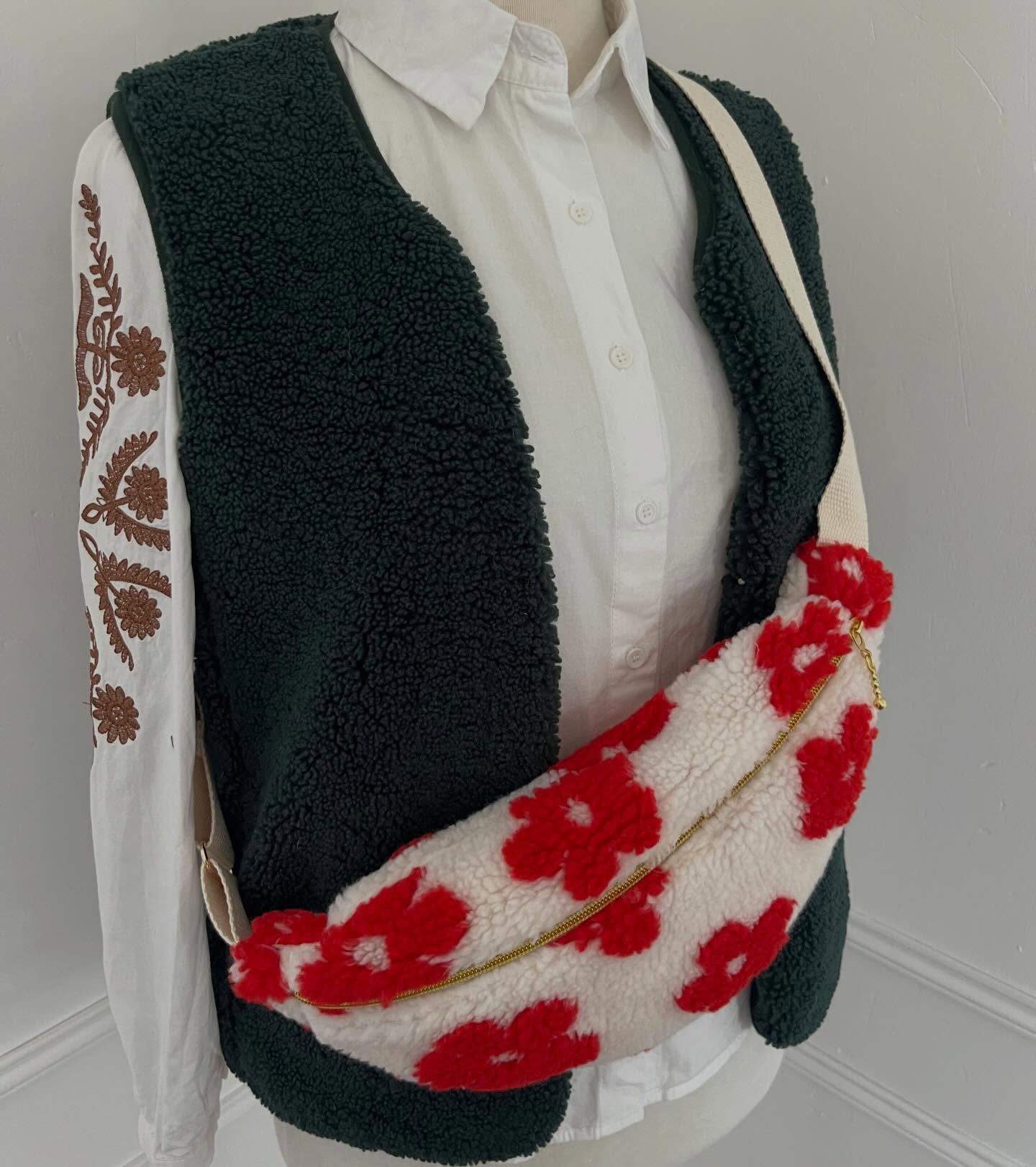 Banane en tissu moumoute blanc à fleurs rouges, portée sur un mannequin